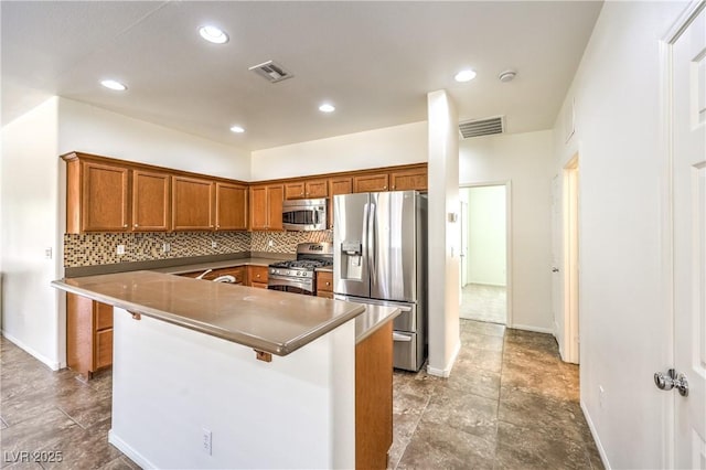 kitchen with brown cabinetry, visible vents, backsplash, and appliances with stainless steel finishes