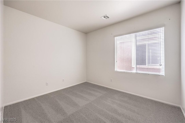 spare room featuring baseboards, visible vents, and carpet floors