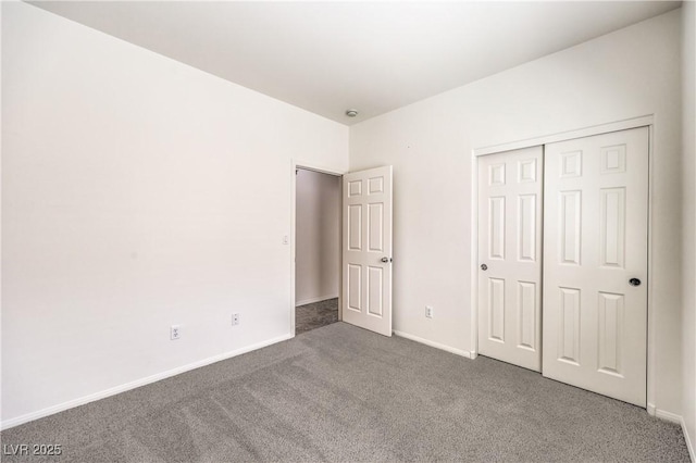 unfurnished bedroom with baseboards, carpet flooring, and a closet