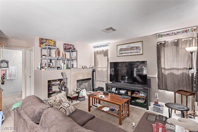 living room with a tile fireplace and visible vents