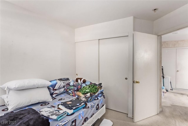 bedroom featuring light colored carpet and a closet