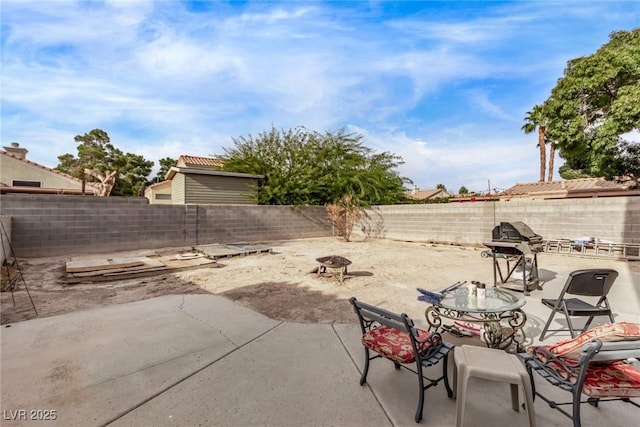 view of patio / terrace with a fenced backyard, a grill, and an outdoor fire pit