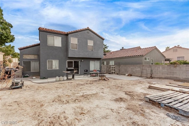 back of house with stucco siding, a patio area, a tiled roof, and a fenced backyard