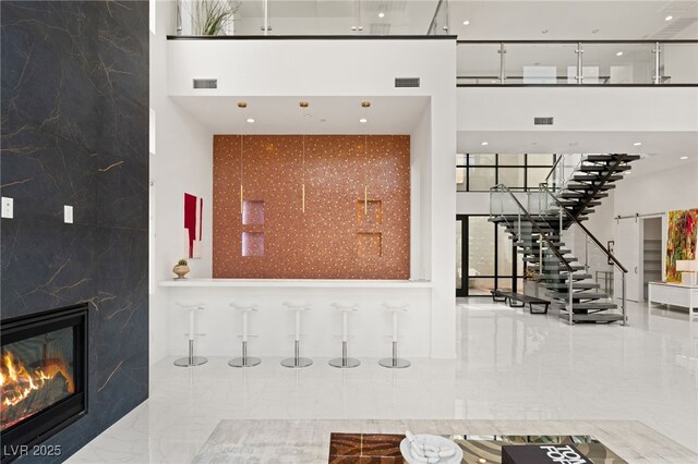 interior space featuring a fireplace, visible vents, and stairs