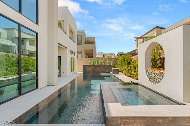view of swimming pool featuring a fenced in pool, a residential view, and an in ground hot tub