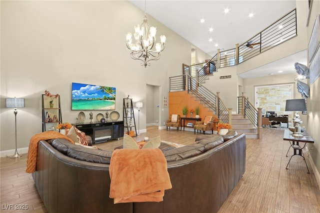 living area with stairway, a towering ceiling, and baseboards