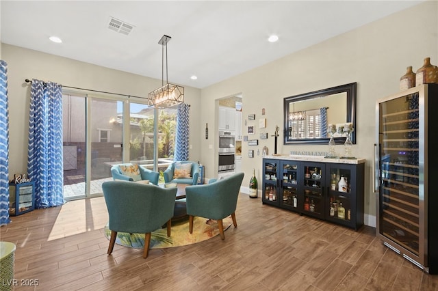 dining area with recessed lighting, beverage cooler, wood finished floors, visible vents, and baseboards