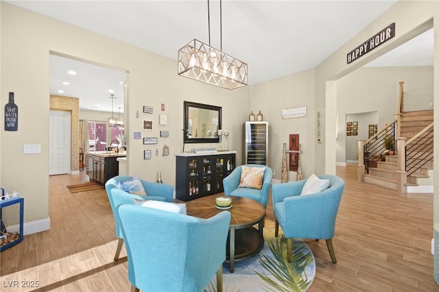 living area with stairway, a notable chandelier, light wood finished floors, and recessed lighting
