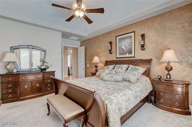 bedroom with visible vents, a ceiling fan, and light carpet