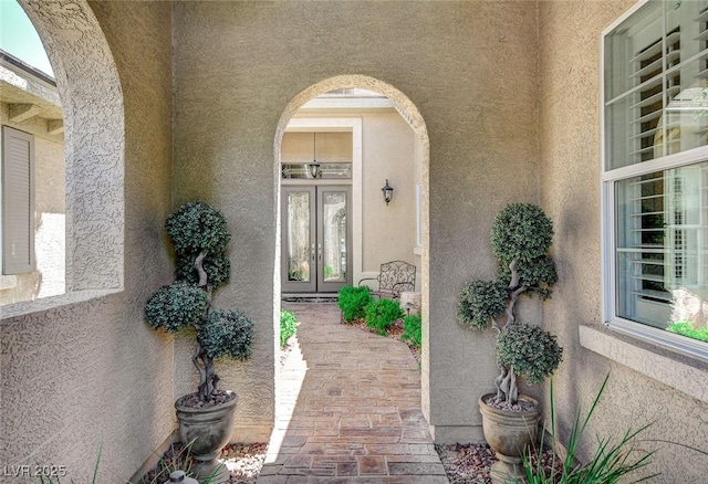 entrance to property featuring stucco siding and french doors
