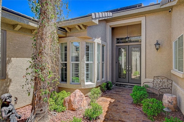 property entrance featuring french doors and stucco siding
