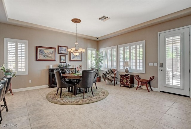 dining room featuring light tile patterned floors, a raised ceiling, baseboards, a notable chandelier, and visible vents