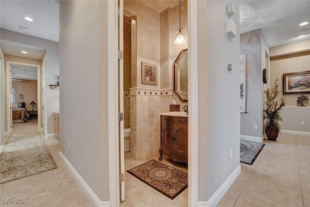 ensuite bathroom featuring recessed lighting, tile patterned floors, toilet, vanity, and ensuite bath