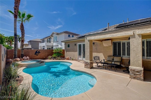 view of pool with outdoor lounge area, a pool with connected hot tub, a fenced backyard, and a patio