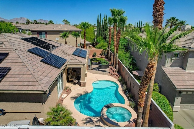 view of pool with a fenced backyard, a mountain view, a patio area, and a pool with connected hot tub