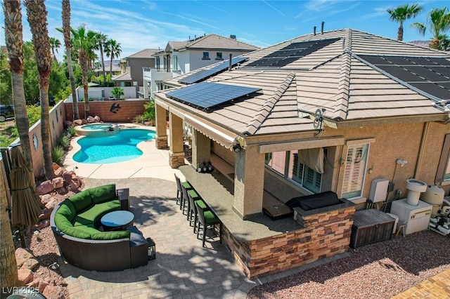 rear view of house with outdoor dry bar, a fenced backyard, stucco siding, a patio area, and a tile roof