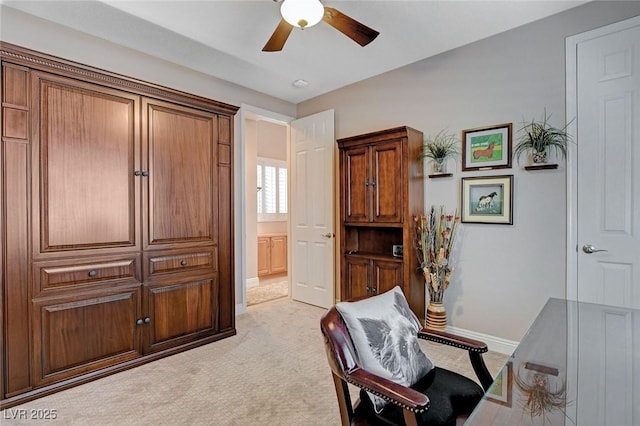 office area featuring light colored carpet, baseboards, and a ceiling fan