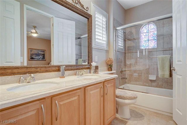 full bath featuring toilet, bath / shower combo with glass door, a sink, and double vanity