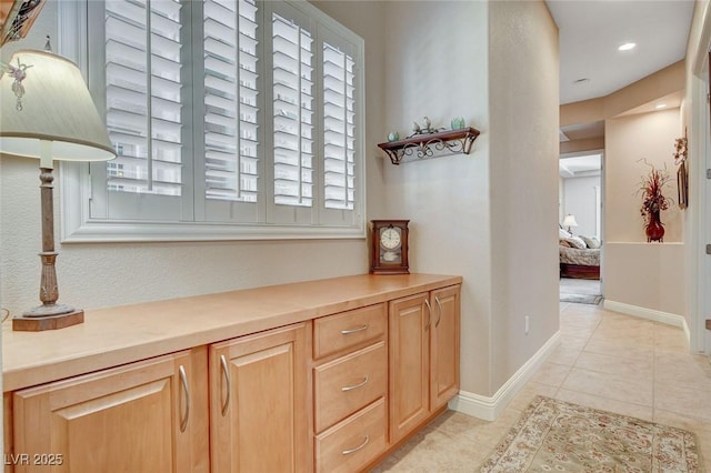 hall with baseboards and light tile patterned floors