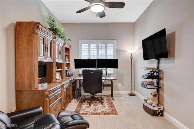 office area with light colored carpet, baseboards, and a ceiling fan