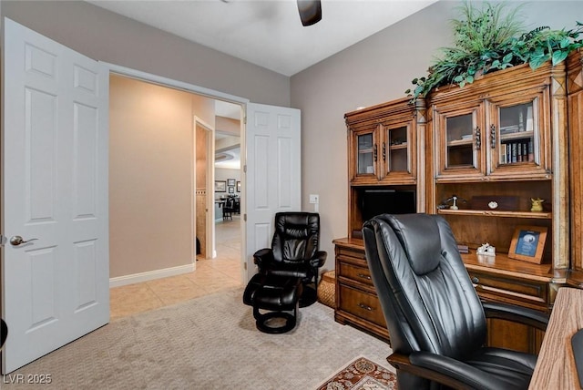 home office featuring light tile patterned flooring, light carpet, baseboards, and ceiling fan