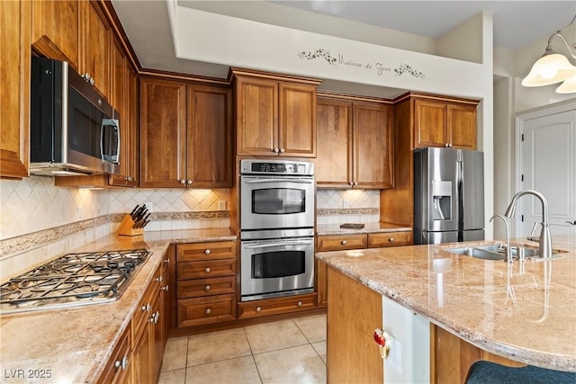 4624 Leon De Oro Dr, Las Vegas, NV 89129 - kitchen with appliances with stainless steel finishes, a sink, light stone counters, and brown cabinets