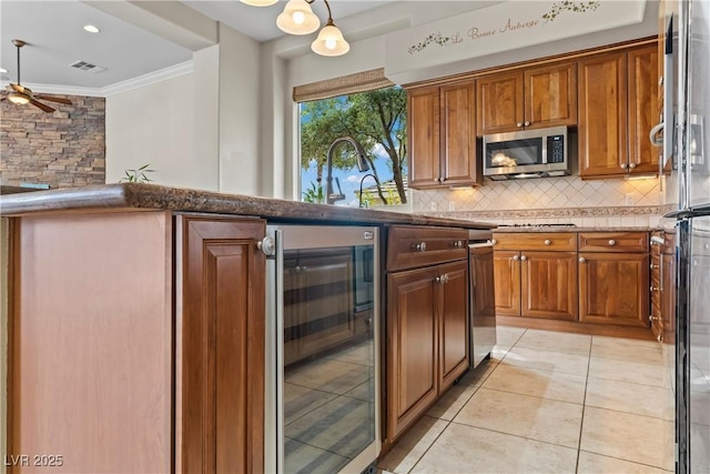 4624 Leon De Oro Dr, Las Vegas, NV 89129 - kitchen with beverage cooler, stainless steel microwave, crown molding, tasteful backsplash, and light tile patterned flooring