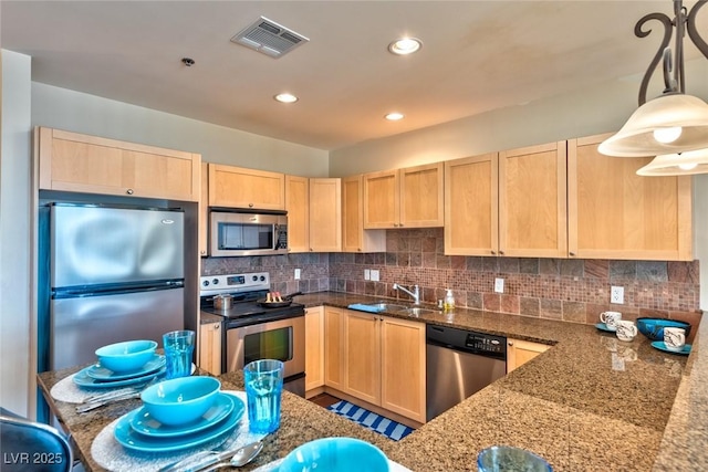 2405 W Serene Ave Unit 703, Las Vegas, NV 89123 - kitchen with stainless steel appliances, a sink, dark stone counters, visible vents, and light brown cabinets