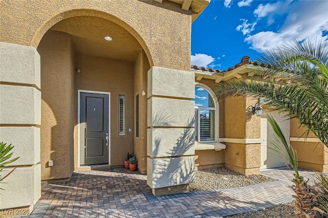 doorway to property featuring stucco siding