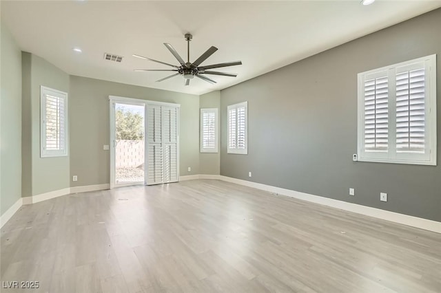 empty room featuring ceiling fan, baseboards, light wood finished floors, and visible vents