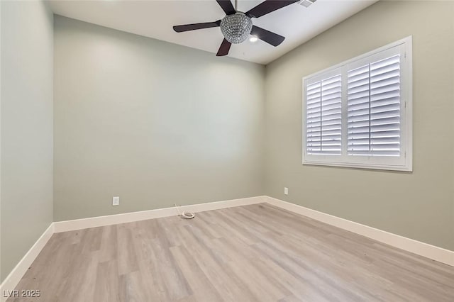 spare room featuring light wood-style floors, baseboards, and ceiling fan