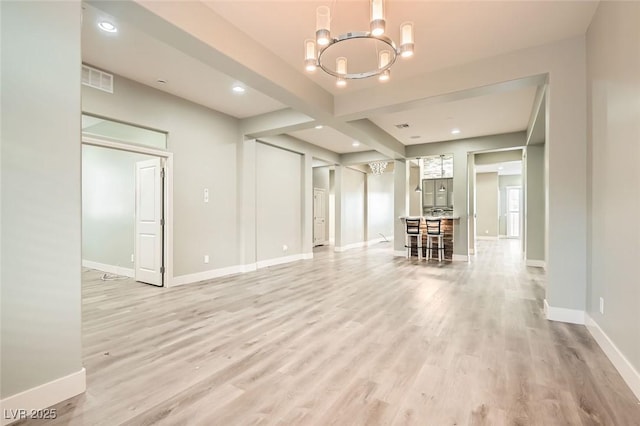 living room featuring light wood-type flooring, baseboards, and a chandelier