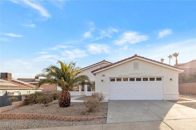 view of front of property featuring an attached garage, stucco siding, fence, and concrete driveway