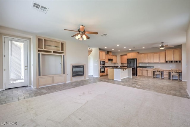 unfurnished living room with recessed lighting, visible vents, a ceiling fan, a sink, and baseboards
