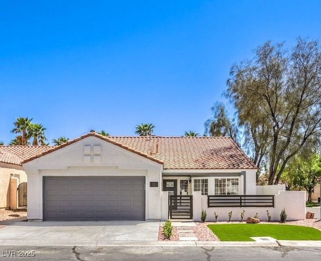mediterranean / spanish-style house with stucco siding, an attached garage, a tile roof, and a fenced front yard