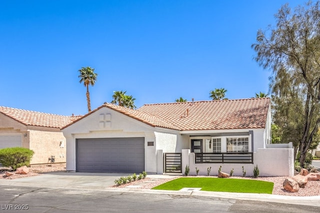mediterranean / spanish-style home featuring a tile roof, concrete driveway, fence, a garage, and stucco siding