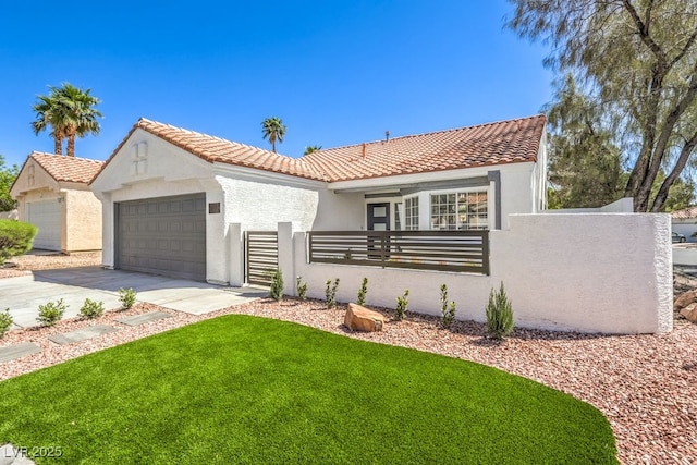 mediterranean / spanish-style house with stucco siding, a tile roof, an attached garage, and a fenced front yard