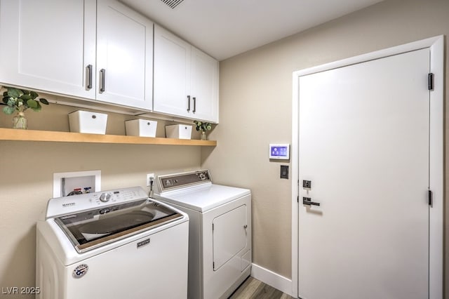 washroom with baseboards, washer and dryer, light wood-style floors, and cabinet space