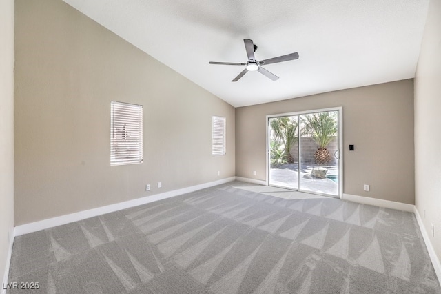 carpeted empty room featuring baseboards, a ceiling fan, and vaulted ceiling