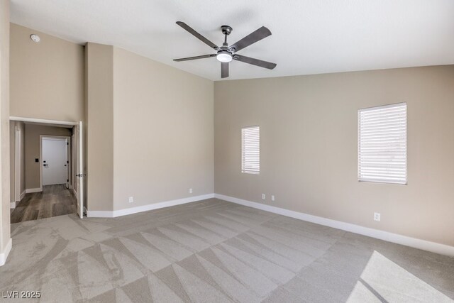 spare room featuring carpet floors, a ceiling fan, and baseboards