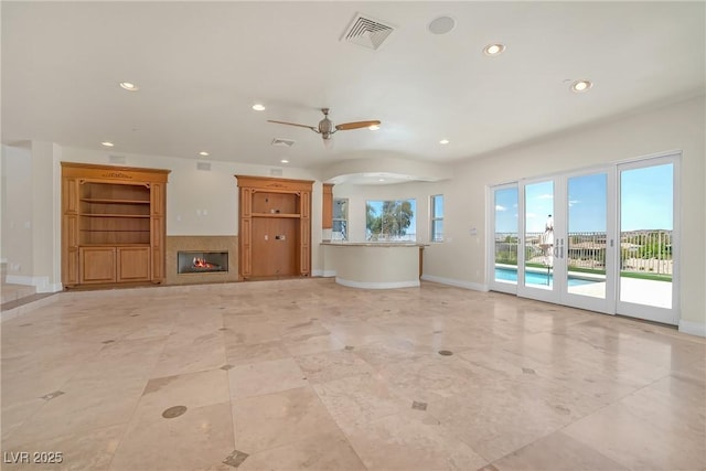 unfurnished living room with visible vents, baseboards, a glass covered fireplace, recessed lighting, and a ceiling fan
