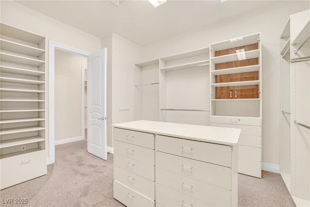 spacious closet featuring light colored carpet