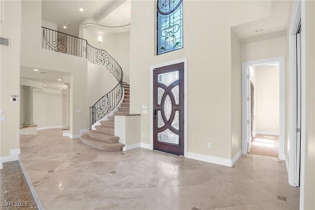 foyer with stairway, visible vents, baseboards, recessed lighting, and a high ceiling