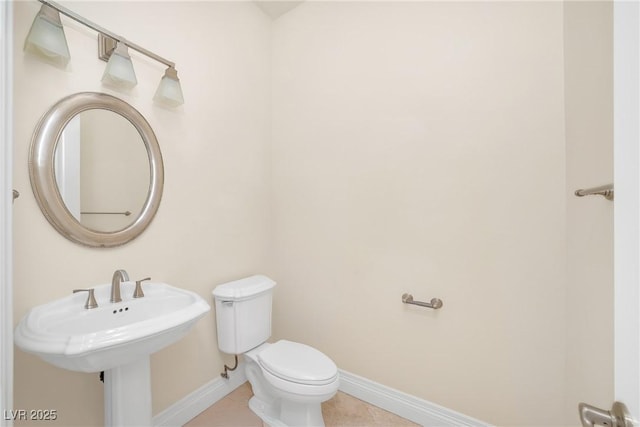 bathroom featuring baseboards, toilet, and tile patterned flooring