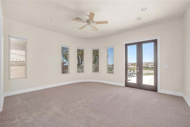 spare room featuring carpet floors, ceiling fan, baseboards, visible vents, and french doors
