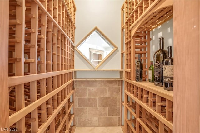 wine area featuring a towering ceiling and stone tile flooring