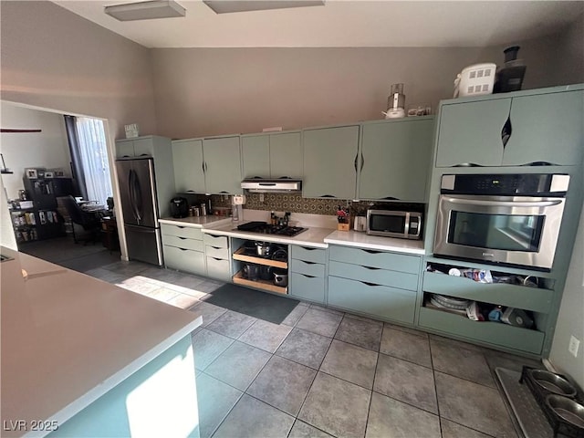kitchen featuring stainless steel appliances, tasteful backsplash, under cabinet range hood, high vaulted ceiling, and light countertops