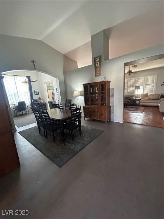 dining space with vaulted ceiling, healthy amount of natural light, a ceiling fan, and finished concrete floors