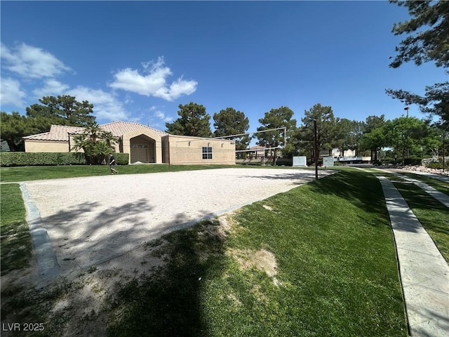 view of home's community with a lawn and volleyball court