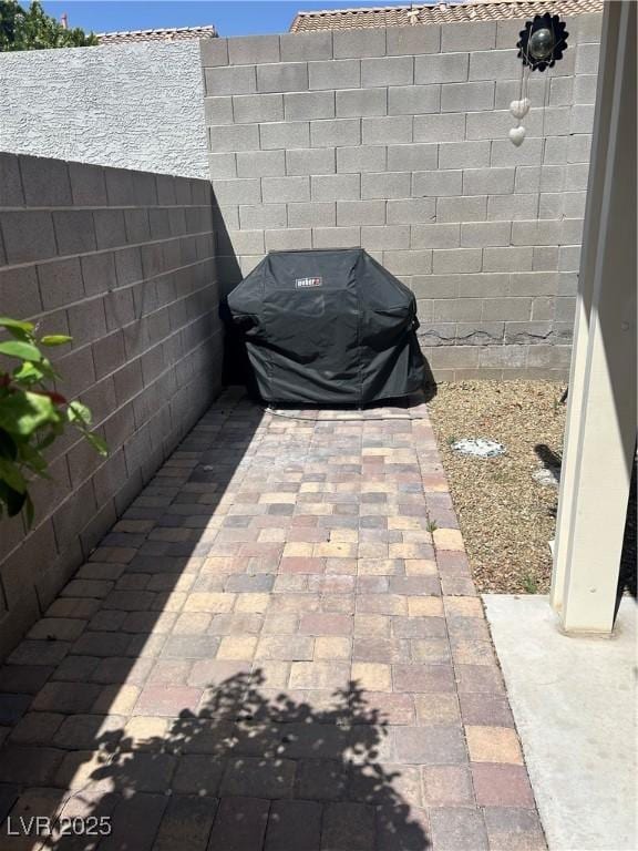 view of patio featuring area for grilling and fence